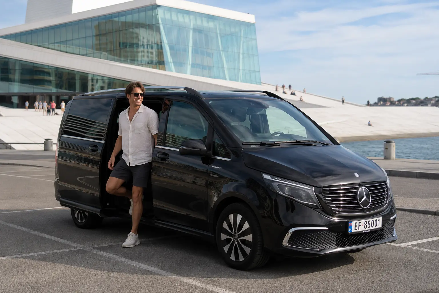 Svart Mercedes EQV fra Husby VIP foran Operahuset i Oslo, med sjåfør ved døren